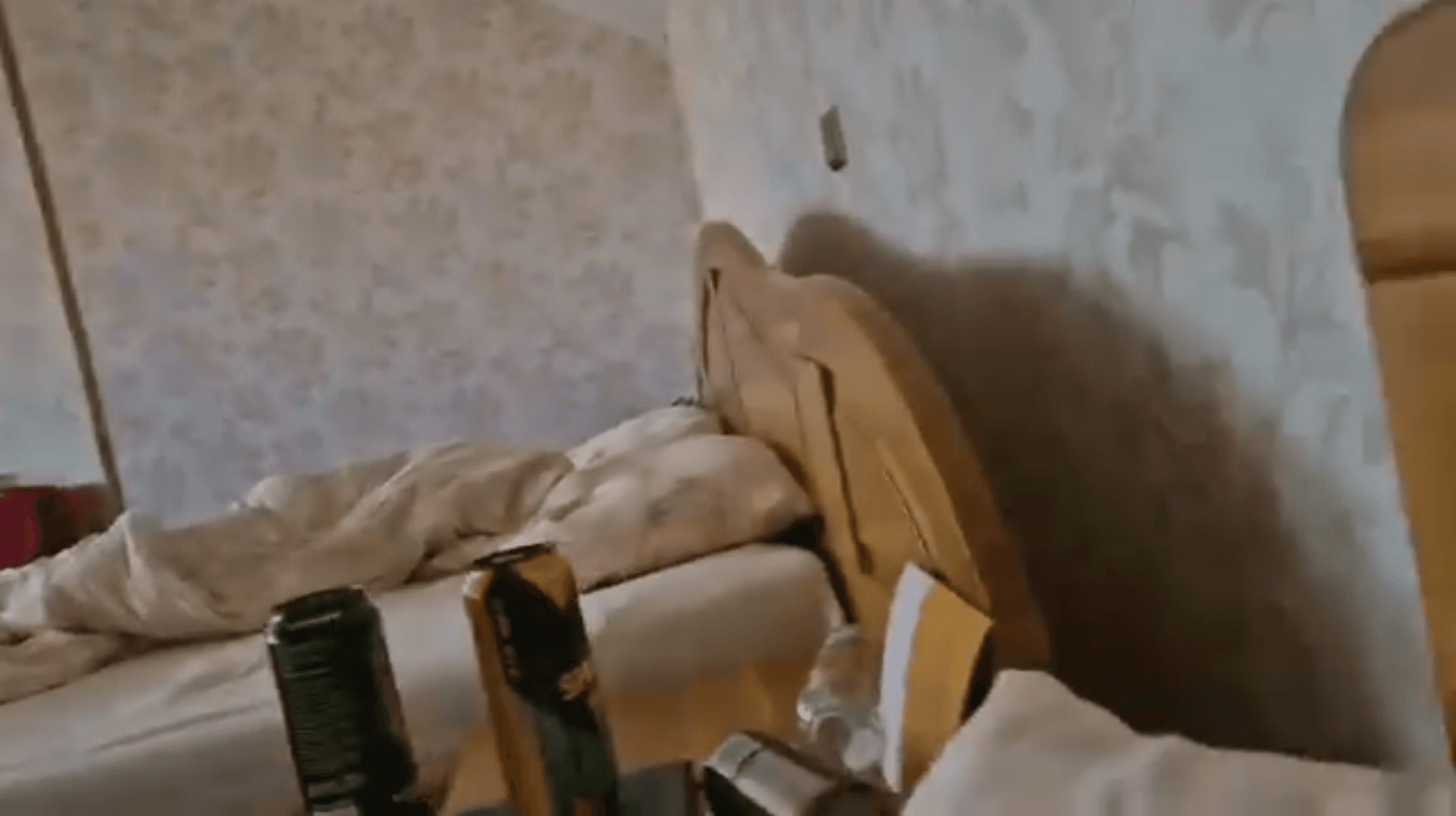 Două doze de băutură așezate lângă un pat