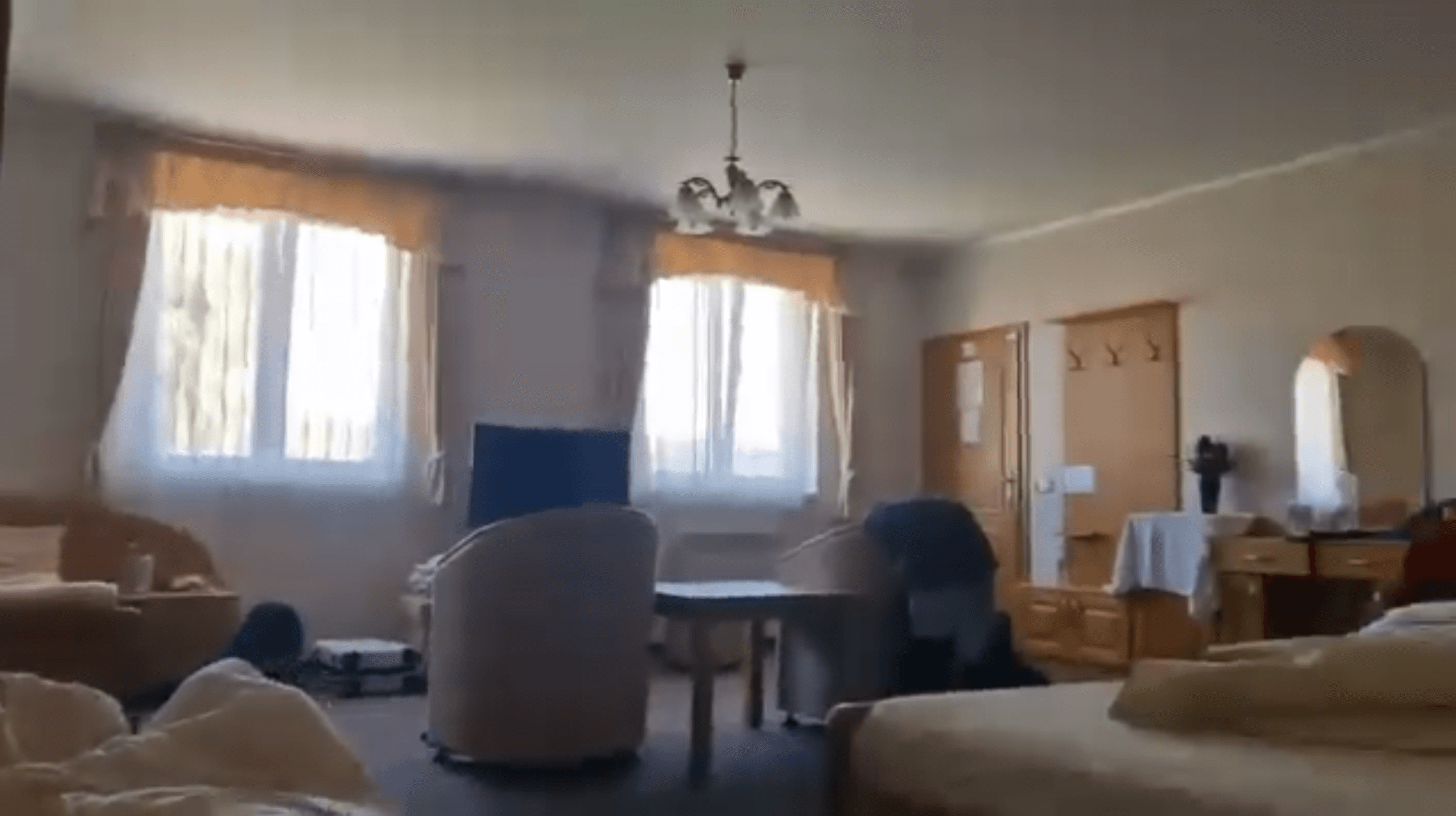 Interiorul unei camere cu paturi, fotolii și mobilier din lemn